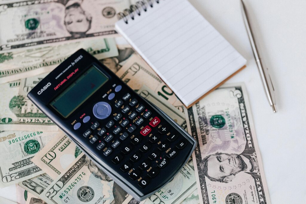pexels-photo-4386366-4386366 From above electronic calculator and notepad placed over United States dollar bills together with metallic pen for budget planning and calculation